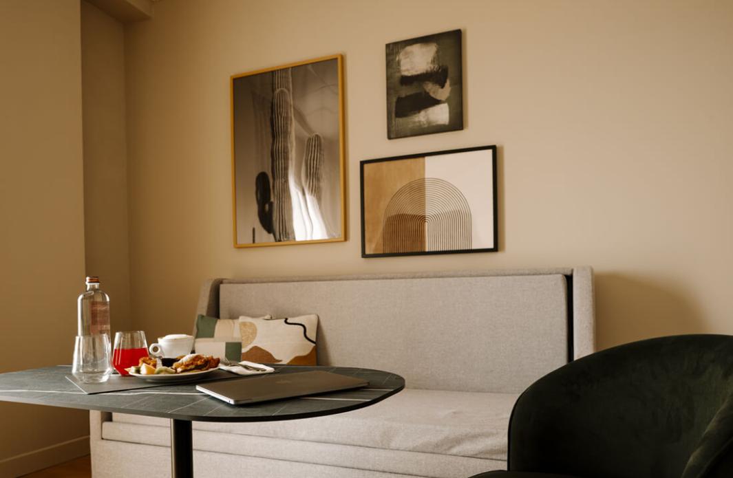 Modern living room with grey sofa, green armchair, and breakfast table.